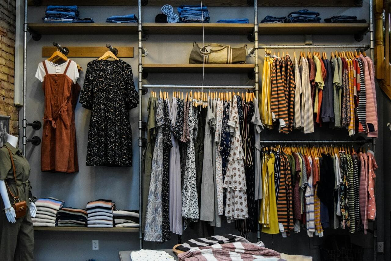 Clothing boutique with dresses and shirts on open rails