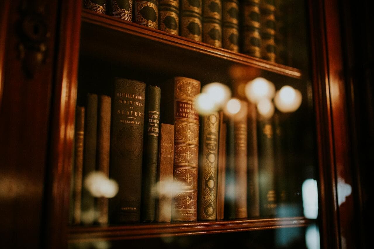 Antique law books on a dark wooden shelf